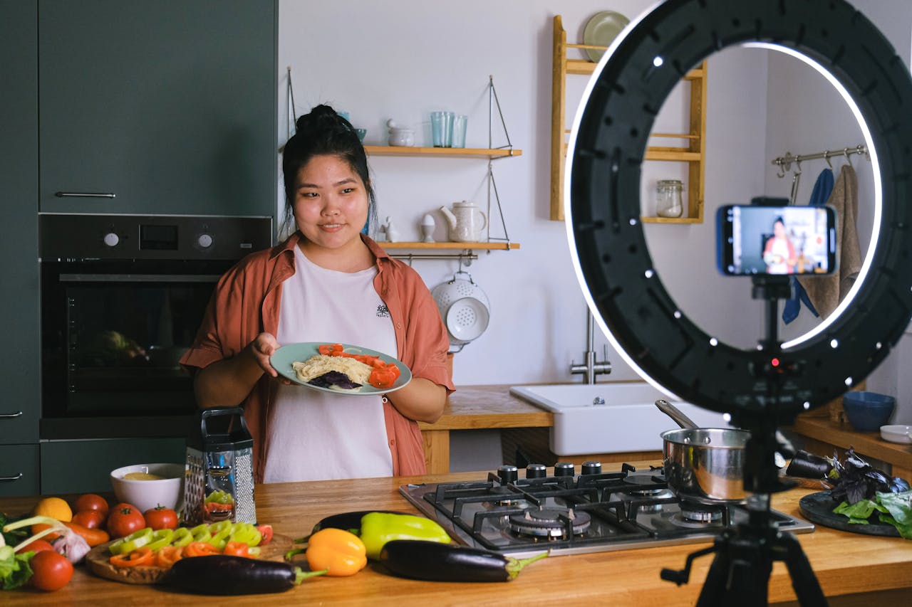 services-01 A woman demonstrates cooking in a stylish kitchen while filming content. Perfect for culinary and lifestyle themes.